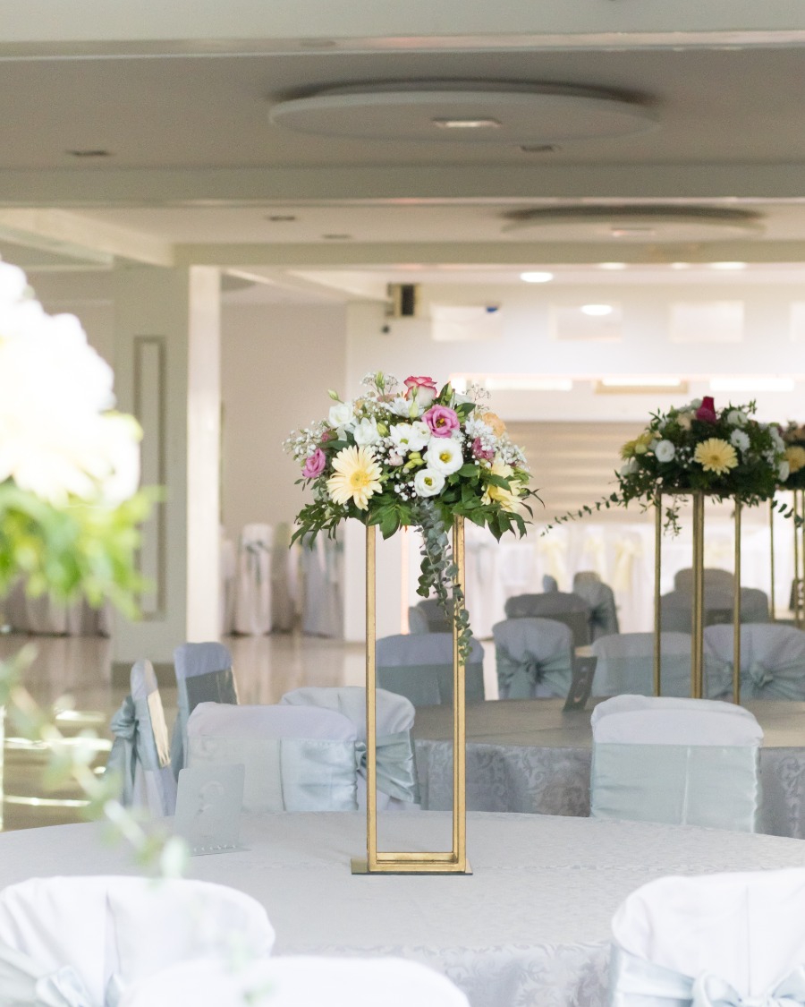 Cvetni aranžman na stolu za goste sastavljena od šarenog cveća i zelenila