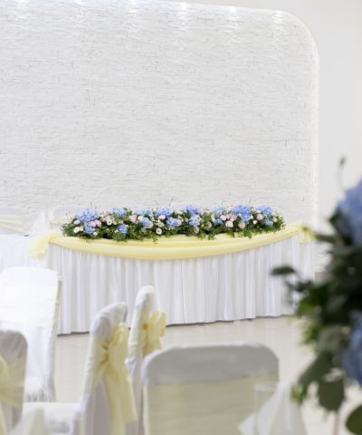 Mladenači sto aranžiran sa plavim i roze cvećem duž celog stola
