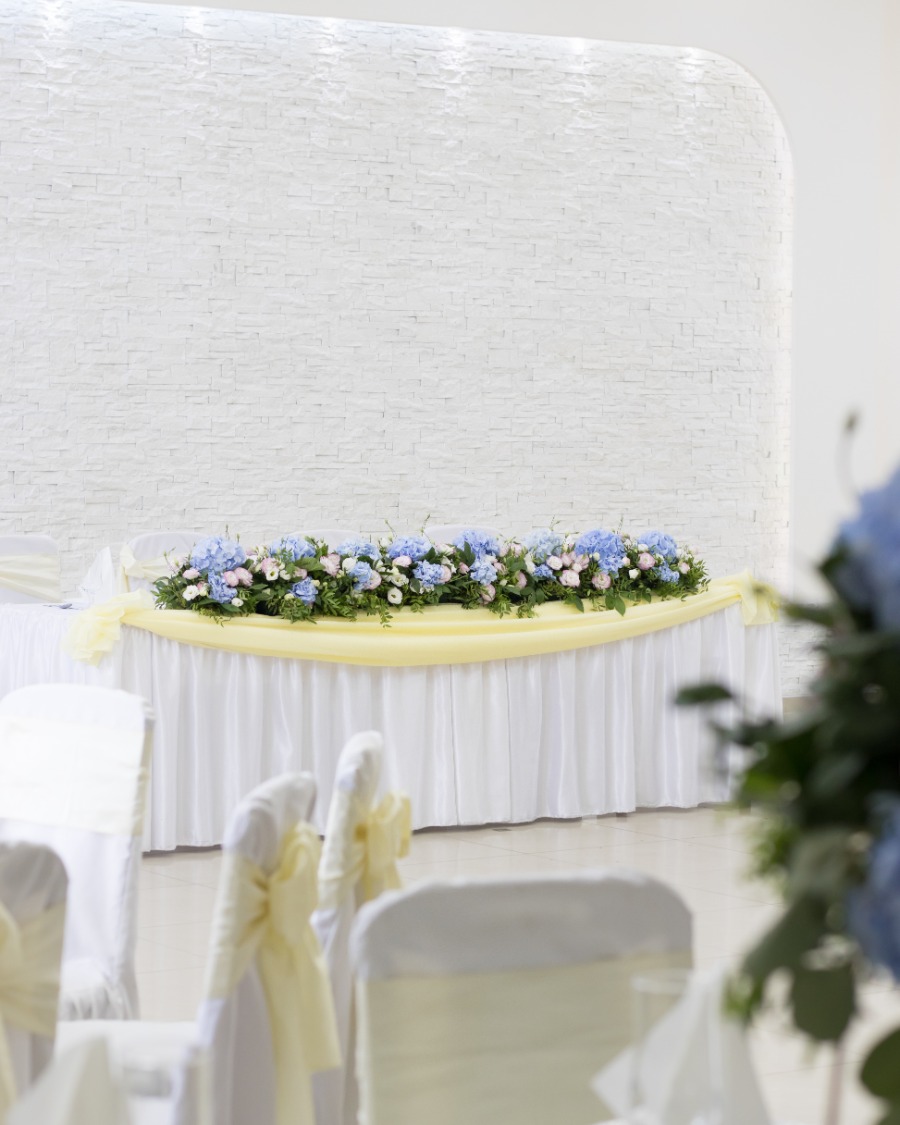 Mladenači sto aranžiran sa plavim i roze cvećem duž celog stola