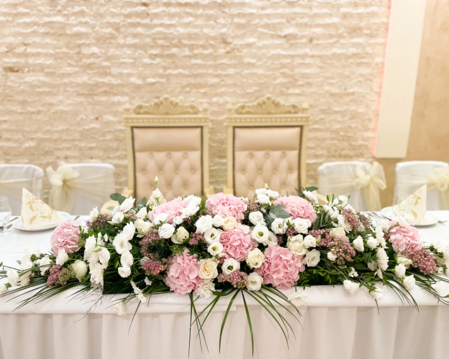 Ikebana na mladenačkom stolu od roze i belog cveća