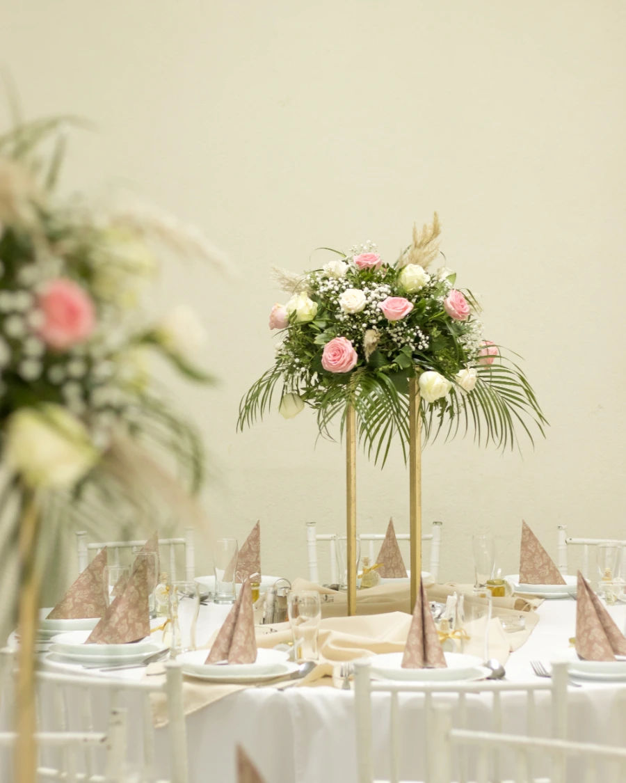 Dekoracija stola za venčanje sa roze i belim ružama u kombinaciji sa pampas travom i egzotičnim zelenilom