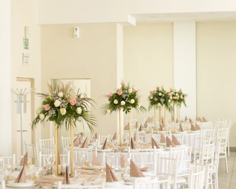 Dekoracija stola za venčanje sa roze i belim ružama u kombinaciji sa pampas travom i egzotičnim zelenilom
