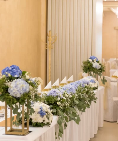 Mladenački sto sa plavim hortenzijama i belim hrizantemama