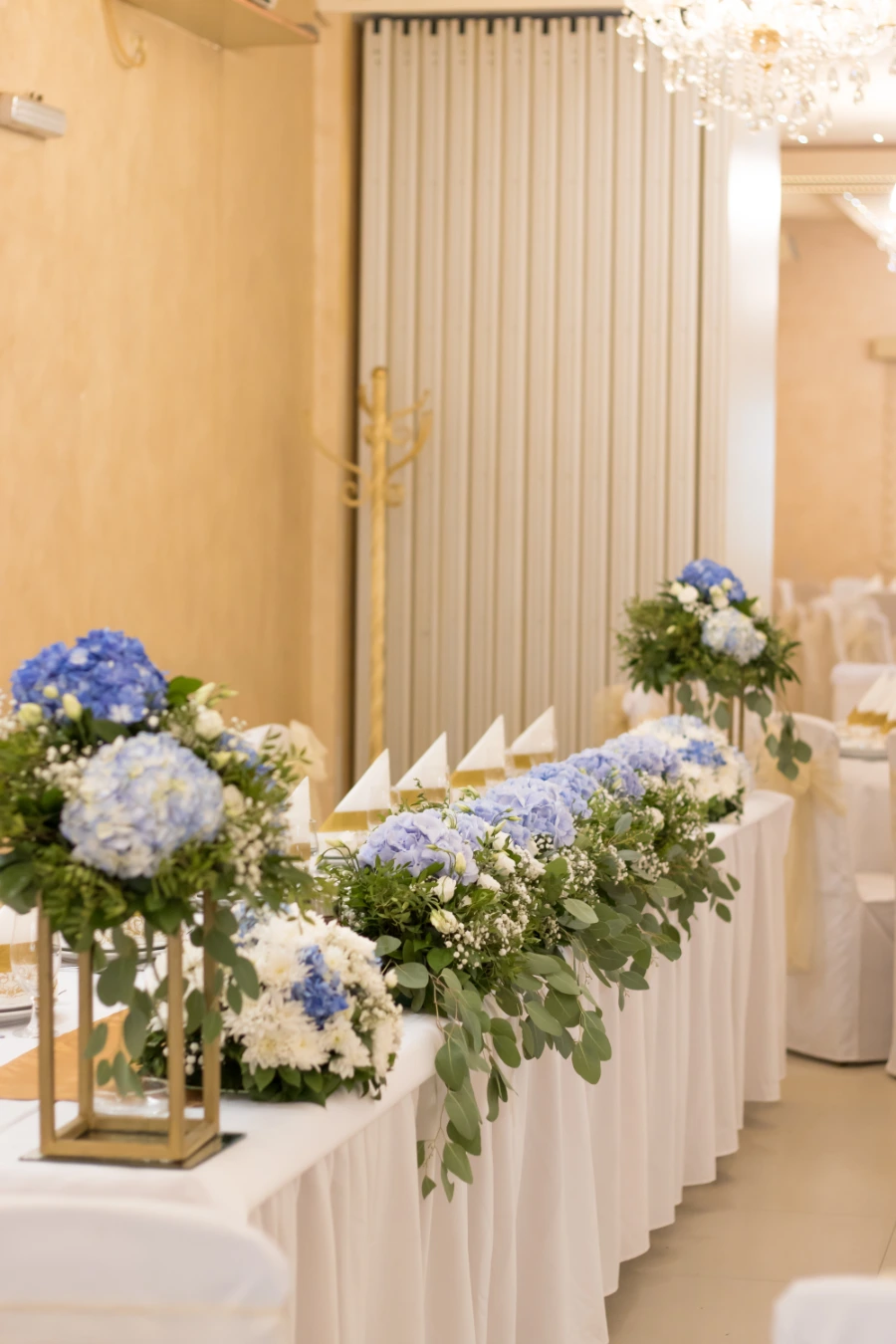 Mladenački sto sa plavim hortenzijama i belim hrizantemama